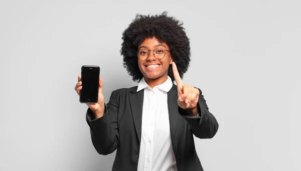 Jovem Afro Empresária Sorrindo Orgulhosa Confiantemente Fazendo Número Posar Triunfalmente — Fotografia de Stock