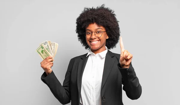 Joven Mujer Negocios Afro Sonriendo Buscando Amigable Mostrando Número Uno —  Fotos de Stock