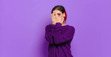  Korkuyor ya da utanıyor, dikizliyor ya da ellerle yarı kapalı gözlerle gözetliyor.