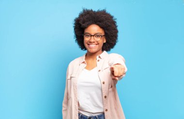  Tatmin olmuş, kendine güvenen, dost canlısı bir gülümsemeyle kameraya bakıp seni seçiyor.