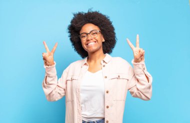  Gülümseyen ve mutlu görünen, dost canlısı ve tatmin olmuş, zafer ya da barış işareti yapan iki elinle