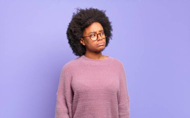  Şaşırmış ve kafası karışmış görünüyor, merak ediyor ya da bir sorunu çözmeye çalışıyor.