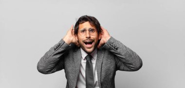 Genç, yakışıklı Hintli bir adam stresli, endişeli, endişeli ya da korkmuş, elleri başının üstünde, hata yaptığında panikliyor. iş kavramı