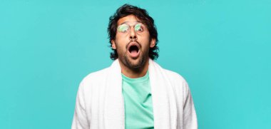 Genç, yakışıklı Hintli adam çok şaşırmış ya da şaşkın görünüyor, ağzı açık bakıyor ve 