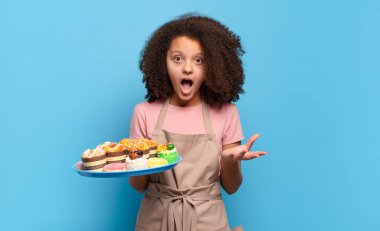 Oldukça afro bir genç ağzı açık ve şaşırmış, şok olmuş ve hayrete düşmüş inanılmaz bir sürprizle. Komik fırıncı konsepti