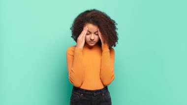 Kız stresli ve hayal kırıklığına uğramış görünüyor, baskı altında çalışıyor, başı ağrıyor ve sorunları var.