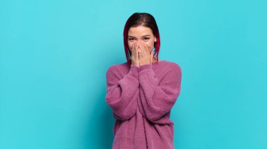  Mutlu, neşeli, şanslı ve şaşkın görünüyor iki eliyle ağzını kapatıyor.