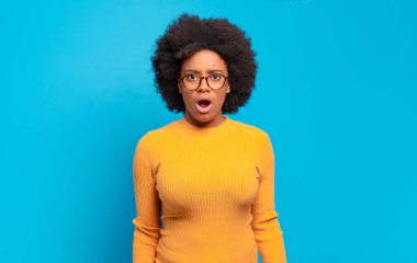  Şok olmuş ya da şaşırmış görünüyor, ağzı açık bakıyor ve 