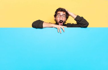 Genç, çılgın, sakallı bir adam duygularını fotokopi aletiyle ifade ediyor.