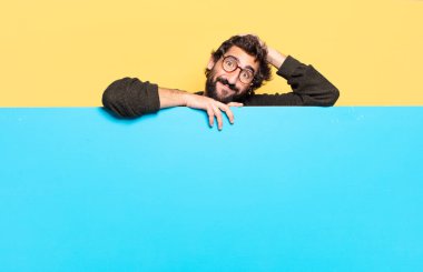 Genç, çılgın, sakallı bir adam duygularını fotokopi aletiyle ifade ediyor.