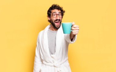 Bornoz giyen genç sakallı adam.