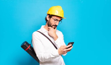 Mavi arka planda genç sakallı mimar.