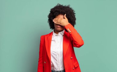  Bir eliyle gözlerini kapatıyor korkmuş ya da endişeli, merak ediyor ya da körü körüne bir sürpriz bekliyor.