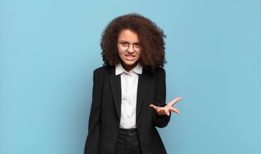 Güzel Afro ergen sinirli, sinirli ve sinirli görünüyor. Ne ya da neyin var diye bağırıyor. mizahi iş konsepti 