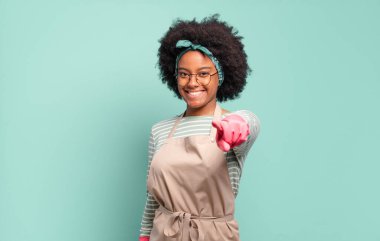 Siyah afro kadın kameraya bakıyor. Tatmin olmuş, kendine güvenen, dost canlısı bir gülümsemeyle seni seçiyor. Oda servisi konsepti... ev konsepti
