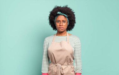 Siyah afro kadın şaşkın ve şaşkın görünüyor, gergin bir hareketle dudağını ısırıyor, sorunun cevabını bilmiyor. Oda servisi konsepti... ev konsepti