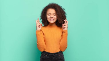  Gülümsüyor ve endişeyle iki parmağımı çaprazlıyorum. Endişeliyim ve iyi şanslar diliyorum.