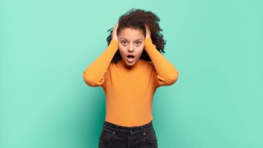  Kötü bir şekilde şoke olmuş, korkmuş ya da endişeli, ağzı sonuna kadar açık ve iki kulağını da eliyle kapatmış.