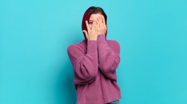  Yüzü ellerle kaplamak, parmaklarının arasından bakmak şaşırmış bir ifadeyle yan tarafa bakmak.