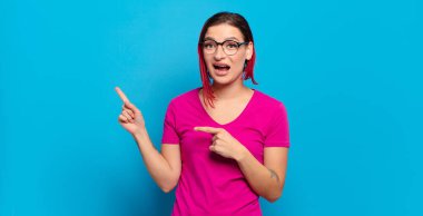  Neşeli ve şaşırmış hissediyorum, şok olmuş bir ifadeyle gülümsüyorum ve bir tarafı işaret ediyorum.