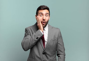 Genç ve yakışıklı iş adamı şok olmuş hissediyor ve ağzı açık halde yüz yüze inanmayarak şaşkınlık içinde bekliyor.