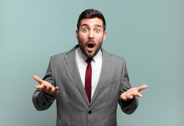 Genç, yakışıklı iş adamı aşırı derecede şaşırmış, şaşırmış, endişeli ve paniklemiş hissediyor. Stresli ve dehşete düşmüş bir bakışla.