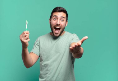 Diş fırçası olan genç yakışıklı adam..