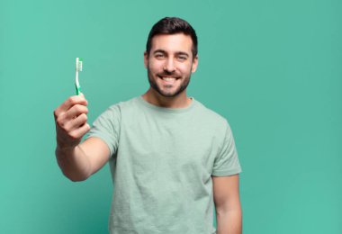 Diş fırçası olan genç yakışıklı adam..