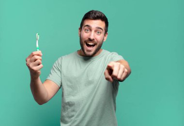 Diş fırçası olan genç yakışıklı adam..