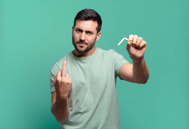 Elinde sigara tutan genç yakışıklı bir adam. sigara içmeyi bırak