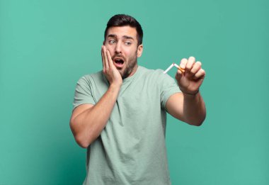 Elinde sigara tutan genç yakışıklı bir adam. sigara içmeyi bırak