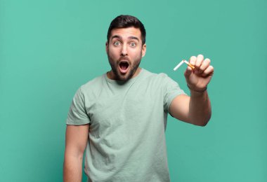 Elinde sigara tutan genç yakışıklı bir adam. sigara içmeyi bırak