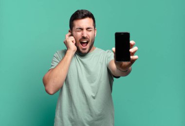 Genç yakışıklı adam cep telefonunu kullanıyor.