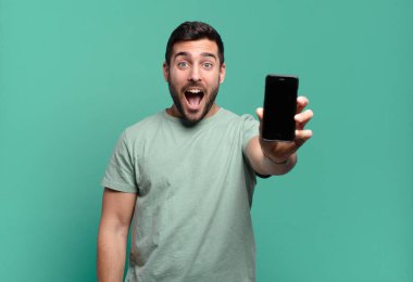 Genç yakışıklı adam cep telefonunu kullanıyor.