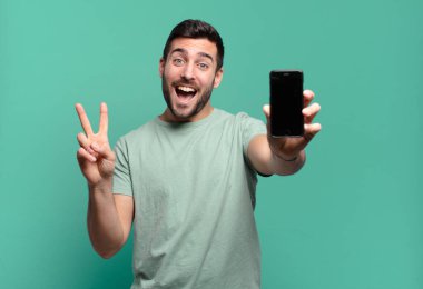 Genç yakışıklı adam cep telefonunu kullanıyor.