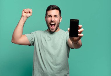 Genç yakışıklı adam cep telefonunu kullanıyor.