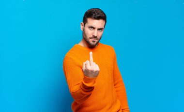 Yakışıklı sarışın adam kızgın, sinirli, isyankar ve agresif orta parmağını sallayarak karşılık veriyor.