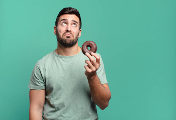 young handsome blond man with a chocolate donut. breakfast concept