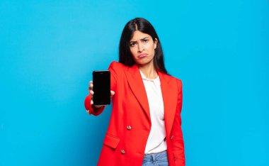 Genç İspanyol kadın üzgün ve mızmızlanıyor. Mutsuz bir bakışla. Olumsuz ve hayal kırıklığına uğramış bir tavırla ağlıyor. telefon ekran kopyalama alanı