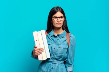 Genç İspanyol öğrenci kadın üzgün, üzgün ya da kızgın hissediyor ve olumsuz bir tavır takınıyor, anlaşmazlık içinde kaşlarını çatıyor.