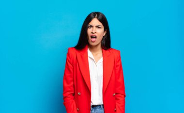 Genç İspanyol iş kadını şok olmuş, kızgın, sinirli ya da hayal kırıklığına uğramış, ağzı açık ve öfkeli görünüyor.