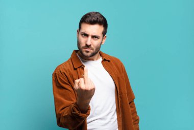 Yakışıklı sarışın adam kızgın, sinirli, isyankar ve agresif orta parmağını sallayarak karşılık veriyor.