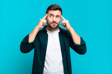 Yakışıklı, yetişkin sarışın bir adam konsantre olmuş ve bir fikir üzerinde kafa yoruyor, bir soruna ya da soruna bir çözüm hayal ediyor.