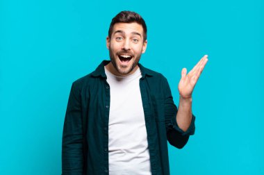 Yakışıklı, sarışın, mutlu, şaşkın ve neşeli bir adam. Pozitif bir tavırla gülümsüyor. Bir çözüm ya da fikri fark ediyor.