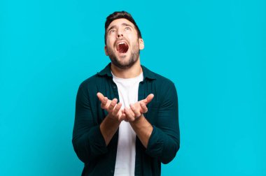 Yakışıklı sarışın adam umutsuz ve hayal kırıklığına uğramış görünüyor, stresli, mutsuz ve sinirli, bağırıyor ve çığlık atıyor.