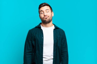 Yakışıklı, sarışın, şapşal ve komik görünen aptal bakışlı, şakacı ve şakacı bir adam.