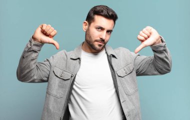 Yakışıklı sarışın adam üzgün, hayal kırıklığına uğramış ya da kızgın görünüyor. Anlaşmazlığa düşmüş, hayal kırıklığına uğramış hissediyor.