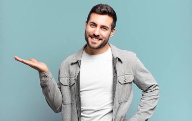 Yakışıklı, yetişkin, sarışın, gülümseyen, kendinden emin, başarılı ve mutlu bir adam, fotokopi alanında fikir ya da konsept gösteriyor.