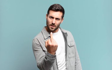 Yakışıklı sarışın adam kızgın, sinirli, isyankar ve agresif orta parmağını sallayarak karşılık veriyor.
