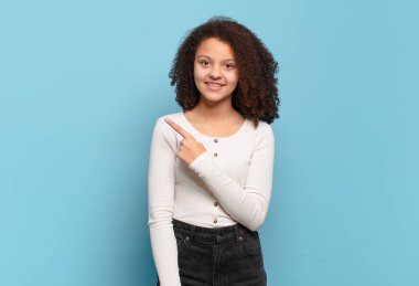  Neşeli bir şekilde gülümseyen, mutlu hisseden, kenarı ve yukarıyı gösteren, kopya uzayda nesneleri gösteren